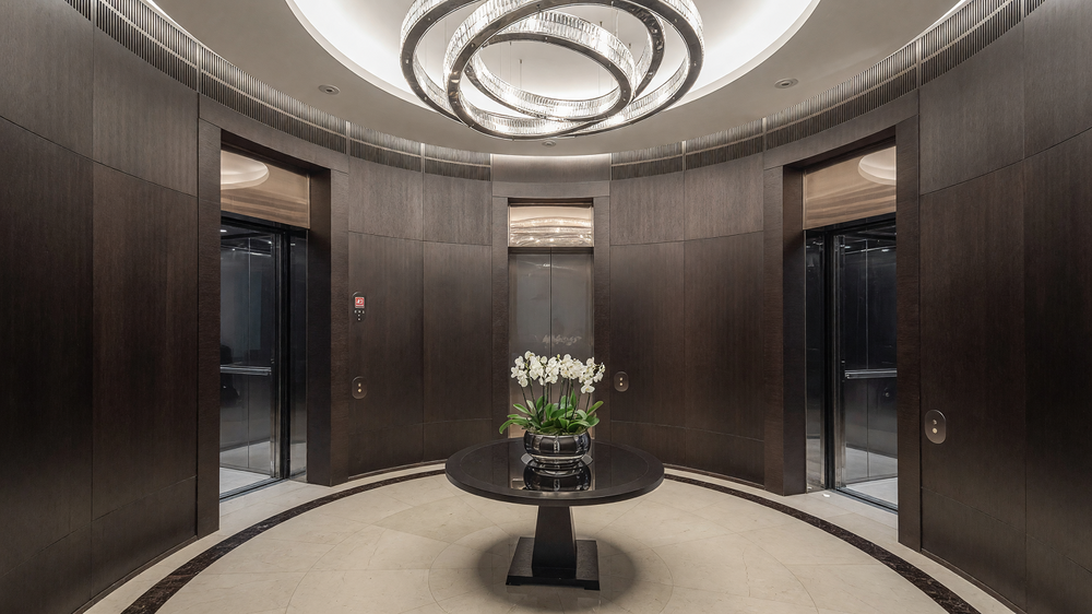 Residents lift lobby - timber panelled walls, circular ceiling feature and console table